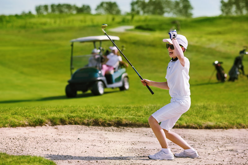 niño jugando golf celebrando